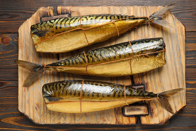 Photo of Tasty smoked fish on wooden table, top view
