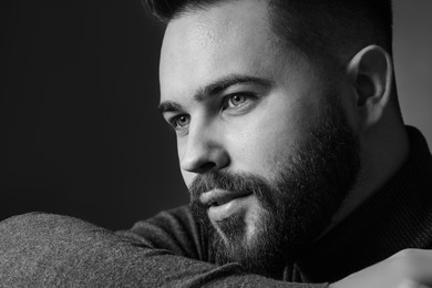 Photo of Portrait of handsome bearded man on dark background. Black and white effect