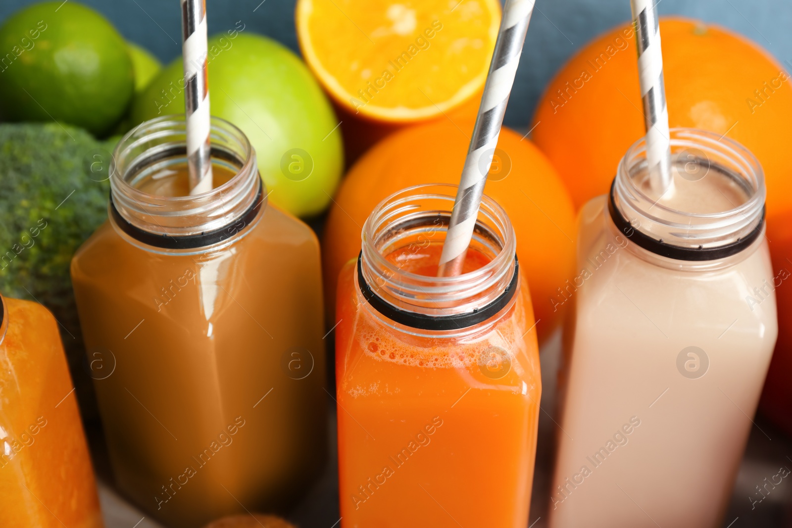 Photo of Bottles with healthy detox smoothies on table, closeup