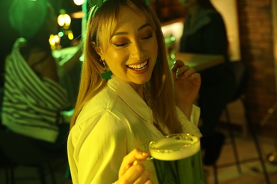 Woman with beer celebrating St Patrick's day in pub