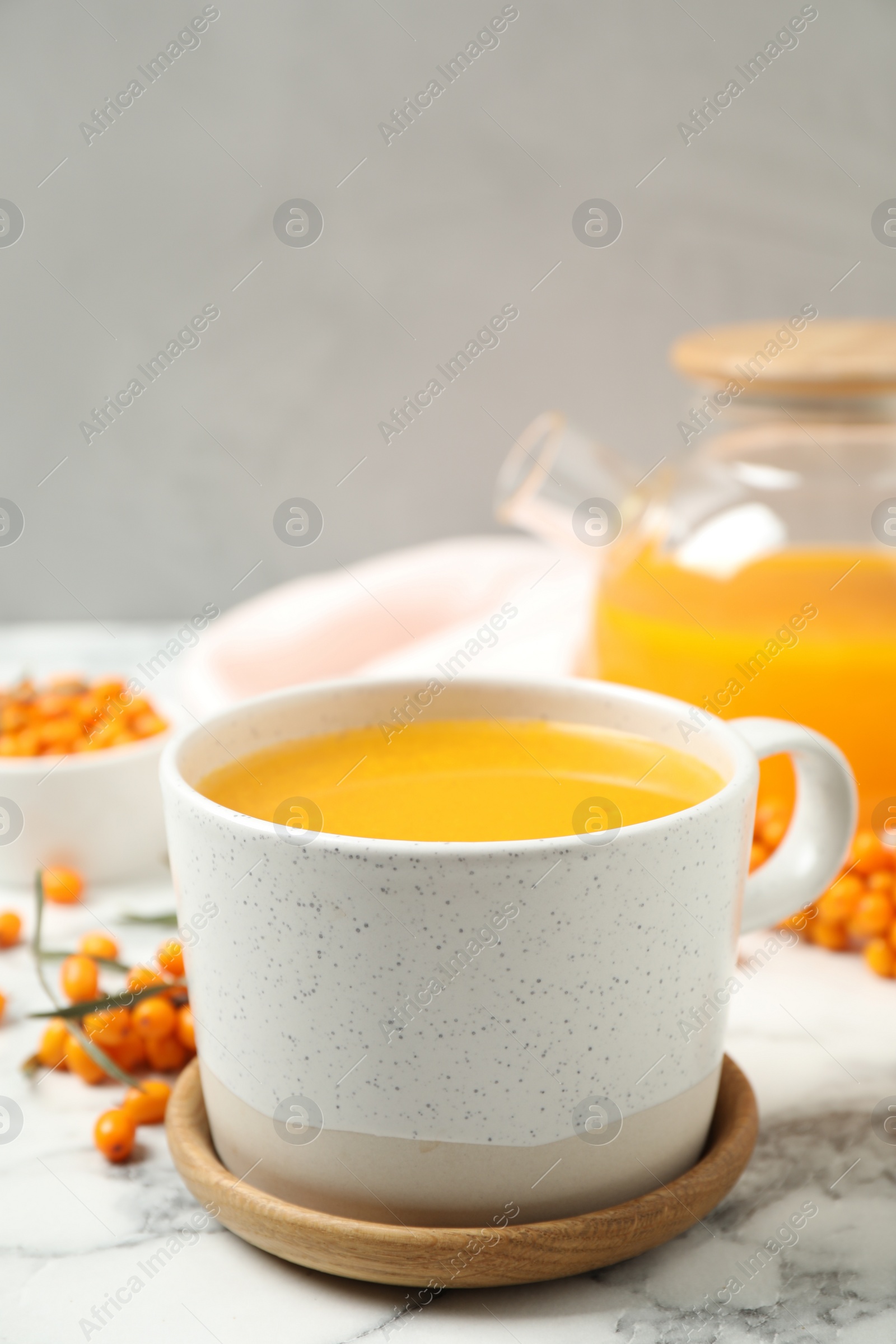 Photo of Delicious sea buckthorn tea on white marble table