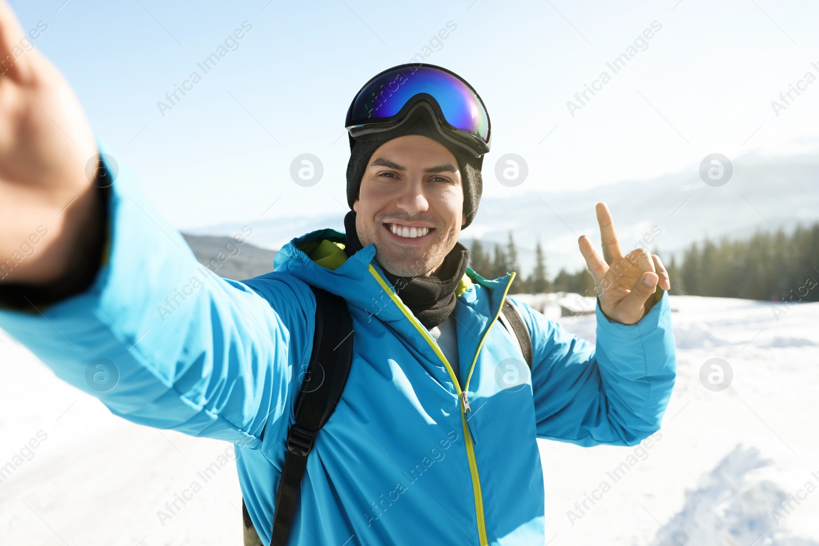 Photo of Happy man taking selfie in mountains. Winter vacation