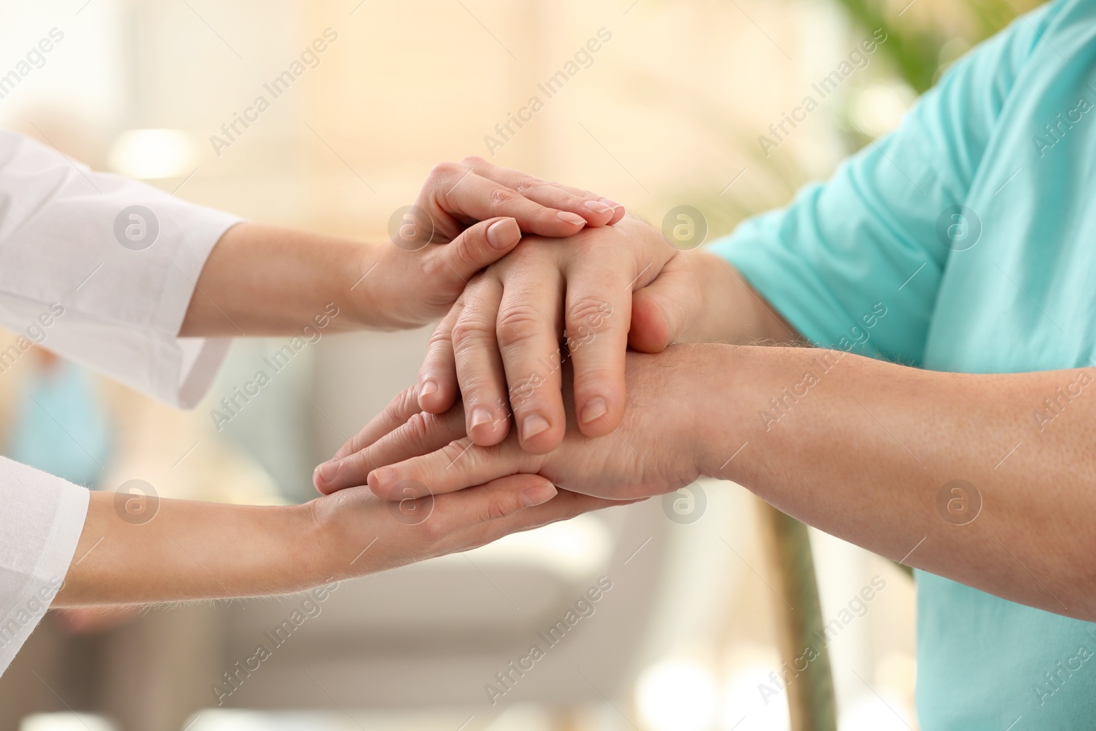 Photo of Nurse comforting elderly man indoors, closeup. Assisting senior generation