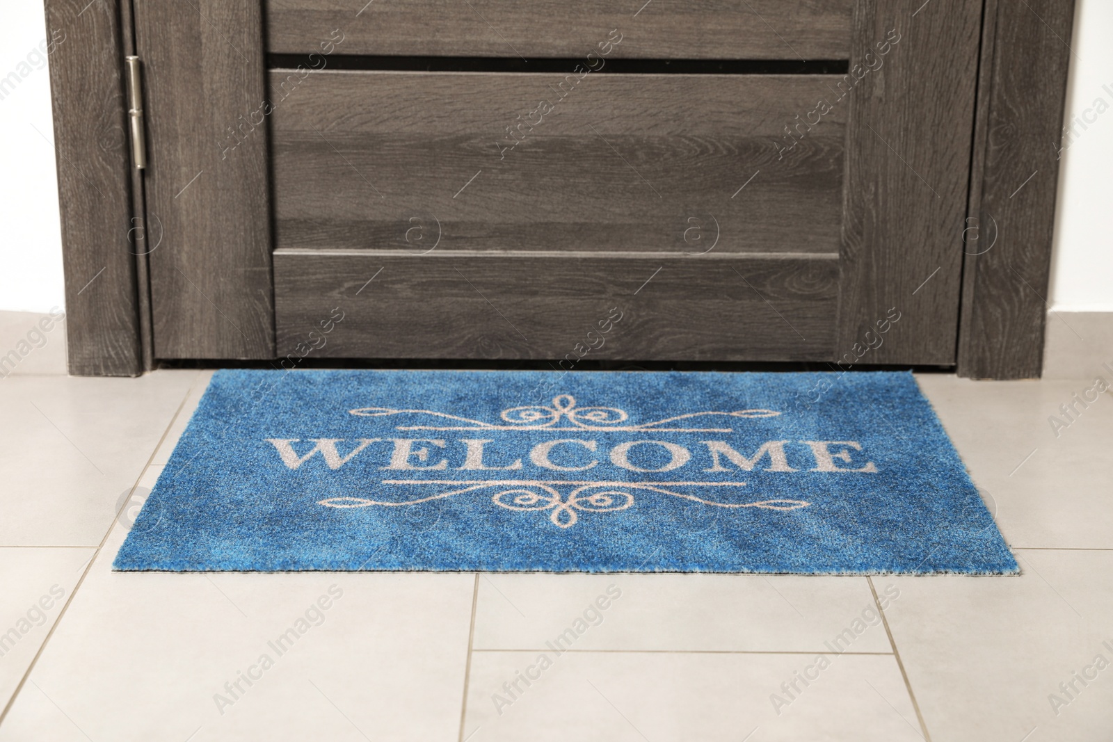 Photo of Beautiful doormat with word Welcome on floor near entrance