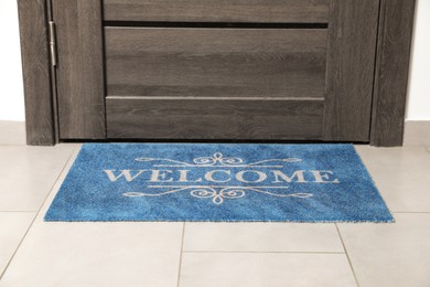 Photo of Beautiful doormat with word Welcome on floor near entrance