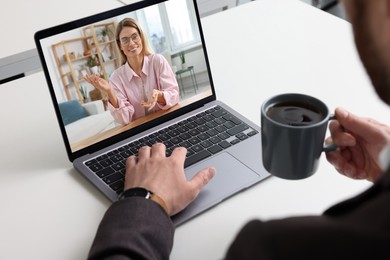Image of Man having video chat with consultant via laptop at white table, closeup