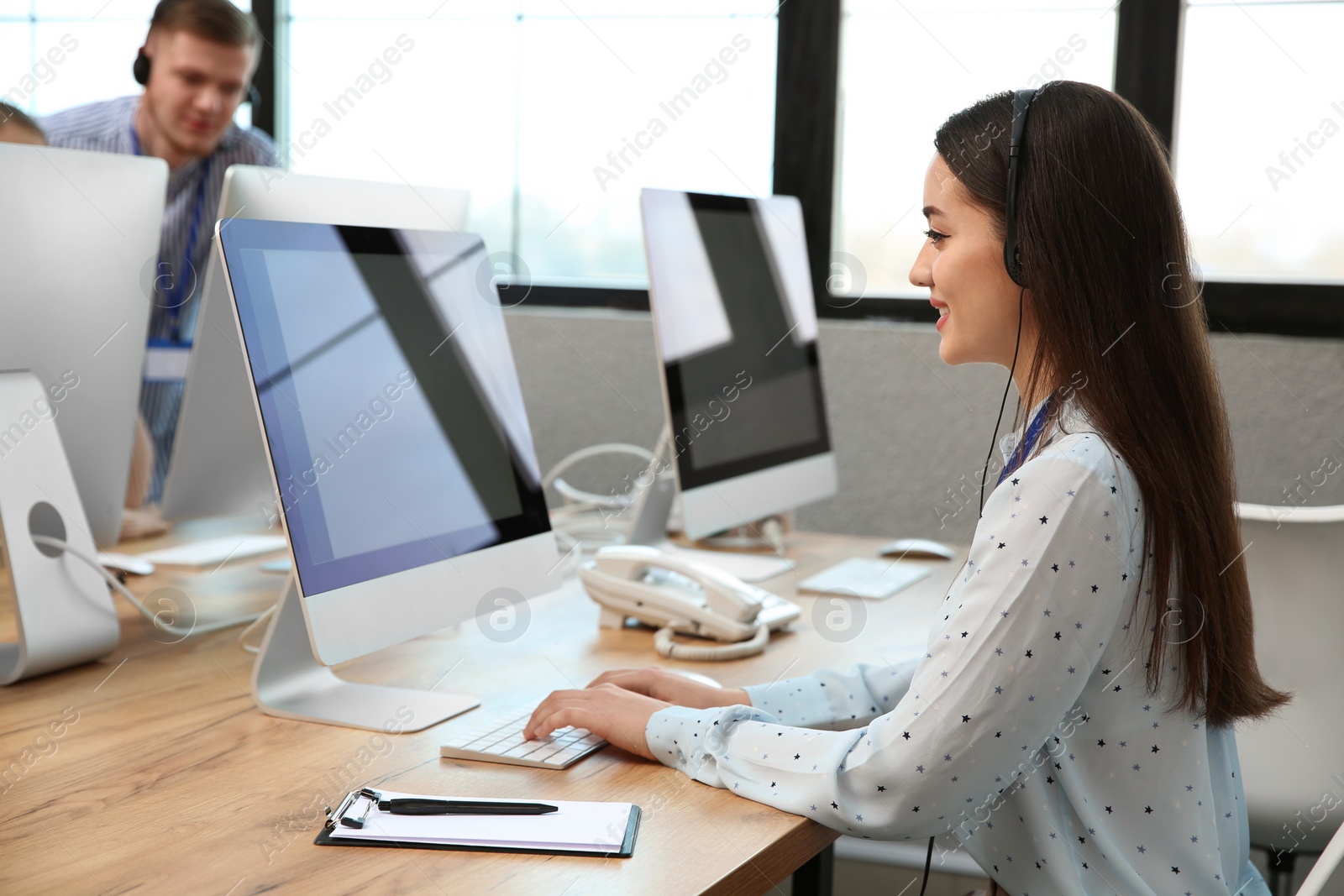 Photo of Technical support operator working with colleagues in office