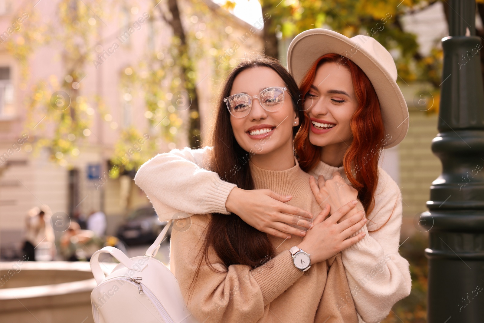 Photo of Happy friends spending time together outdoors on autumn day. Space for text