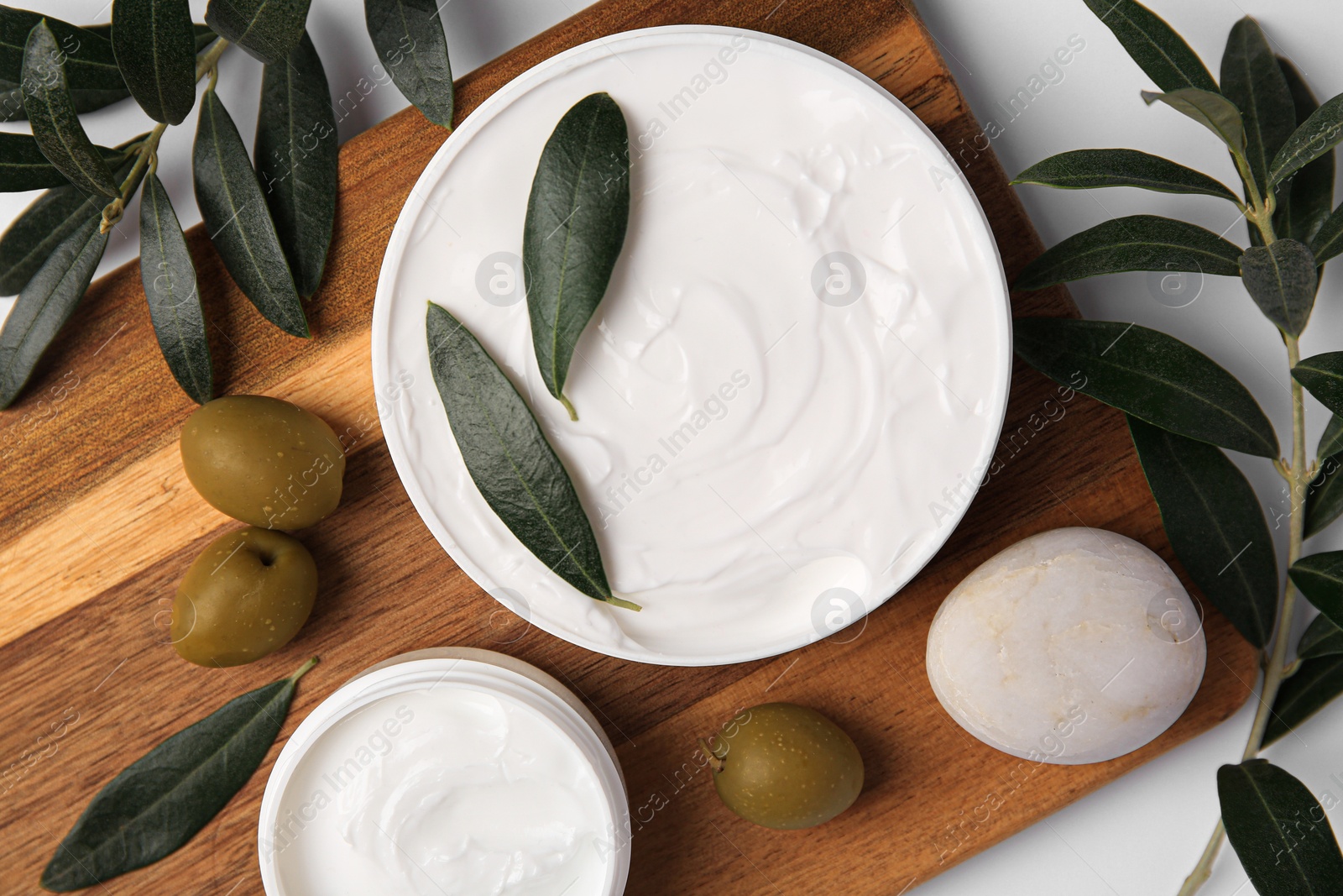 Photo of Flat lay composition with jars of cream and olives on white background