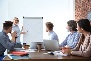 Photo of Business people listening to leader on meeting in office. Professional communication