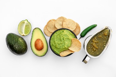 Photo of Delicious guacamole made of avocados, nachos and green pepper on white background, top view