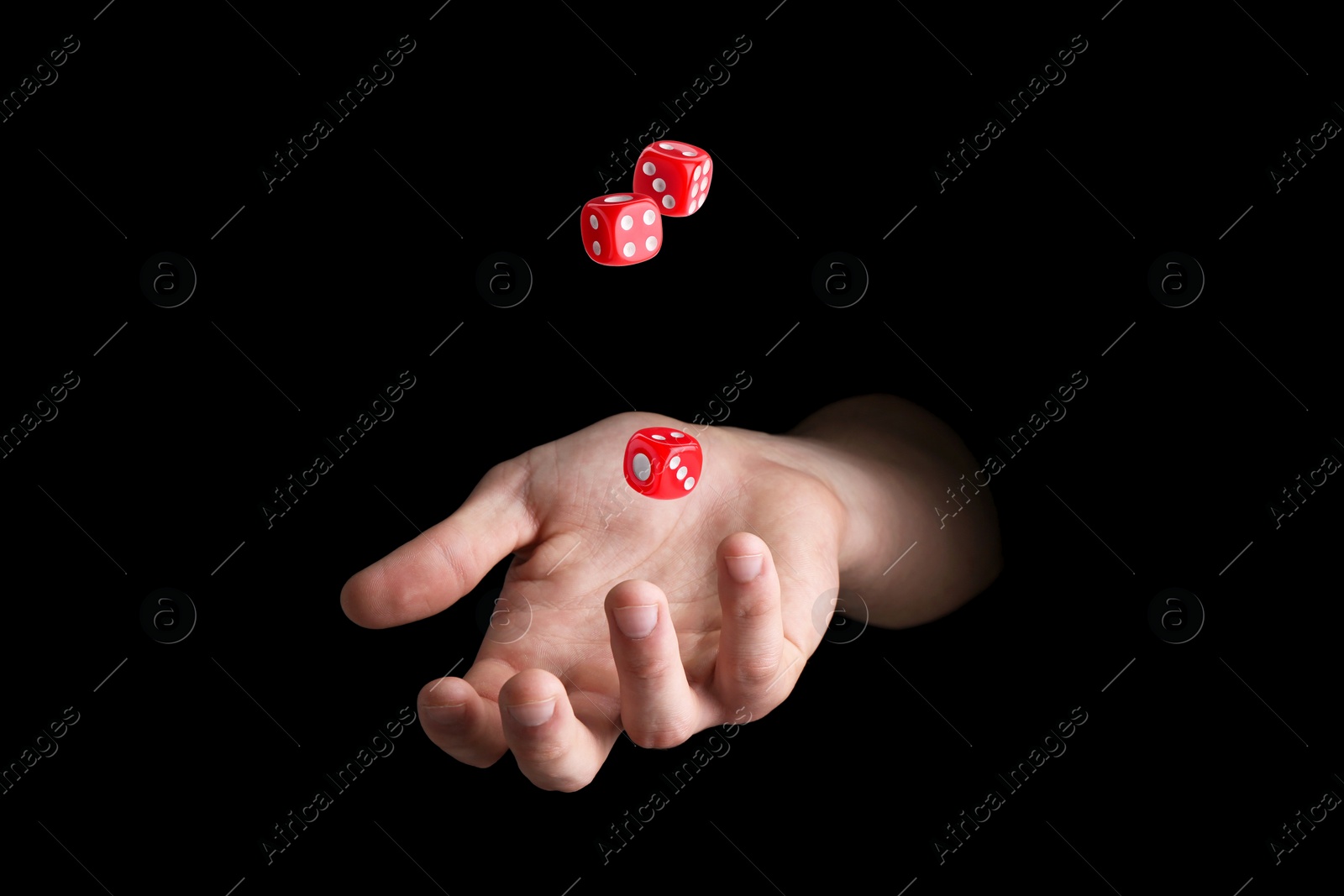 Image of Man throwing red dice on black background, closeup