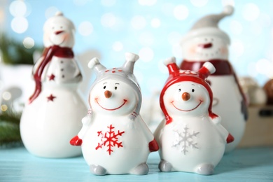 Four decorative snowmen on light blue table