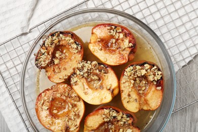 Photo of Delicious baked quinces with nuts and honey in bowl on table, top view