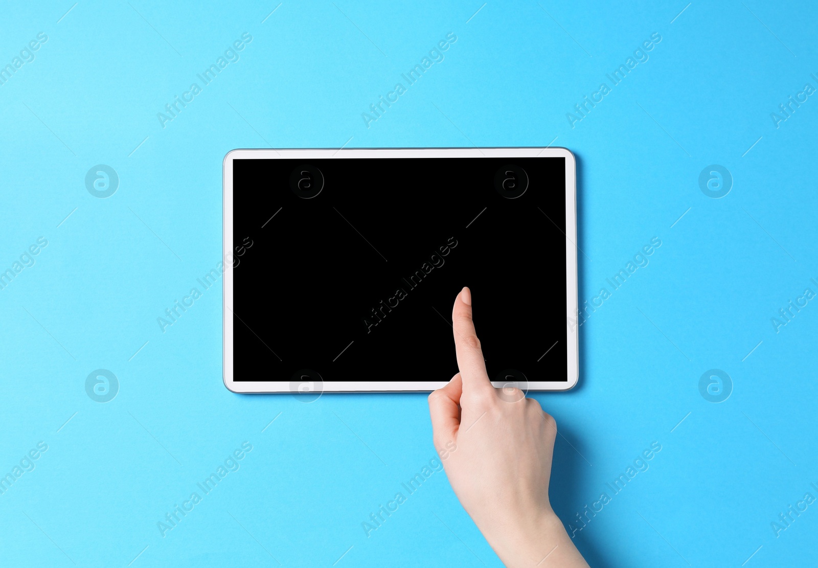 Photo of Online store. Woman using tablet on light blue background, top view