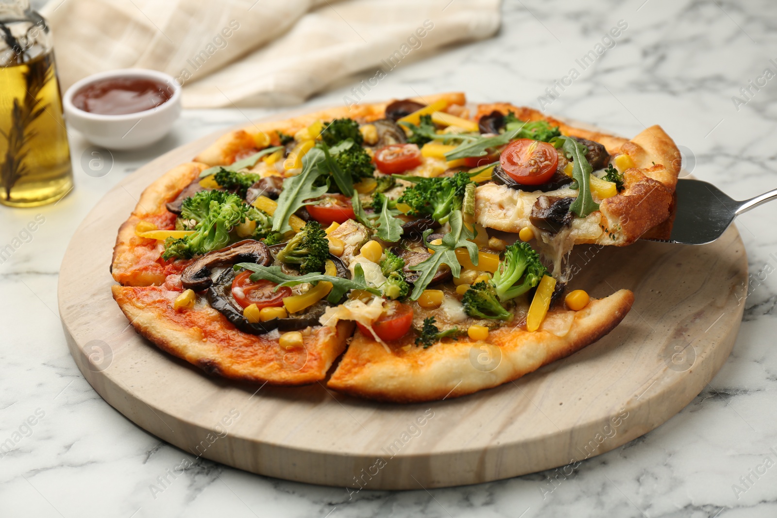 Photo of Taking piece of delicious vegetarian pizza at white marble table, closeup