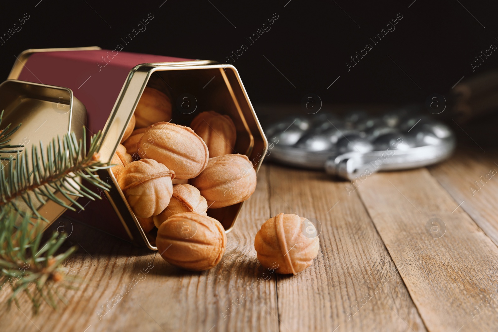 Photo of Homemade walnut shaped cookies with boiled condensed milk and fir branches on wooden table. Space for text