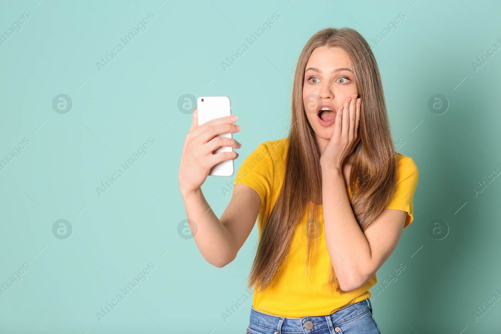 Photo of Young beautiful woman taking selfie against color background