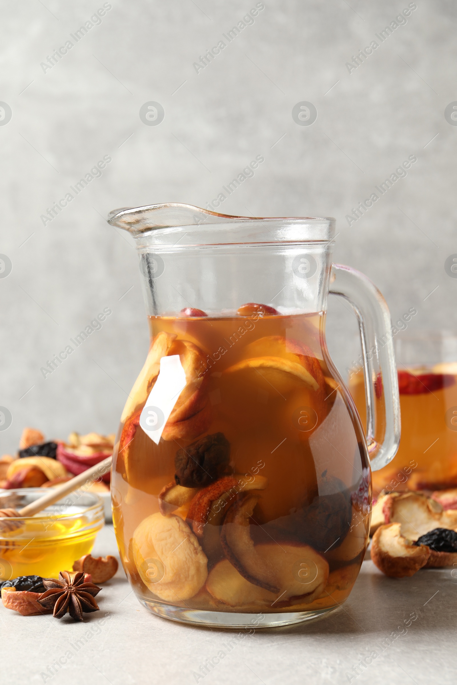 Photo of Delicious compote with dried fruits and ingredients on light grey table