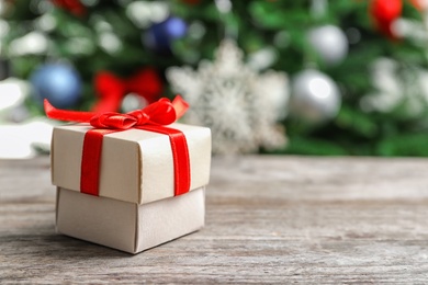 Beautiful gift box and blurred Christmas tree on background