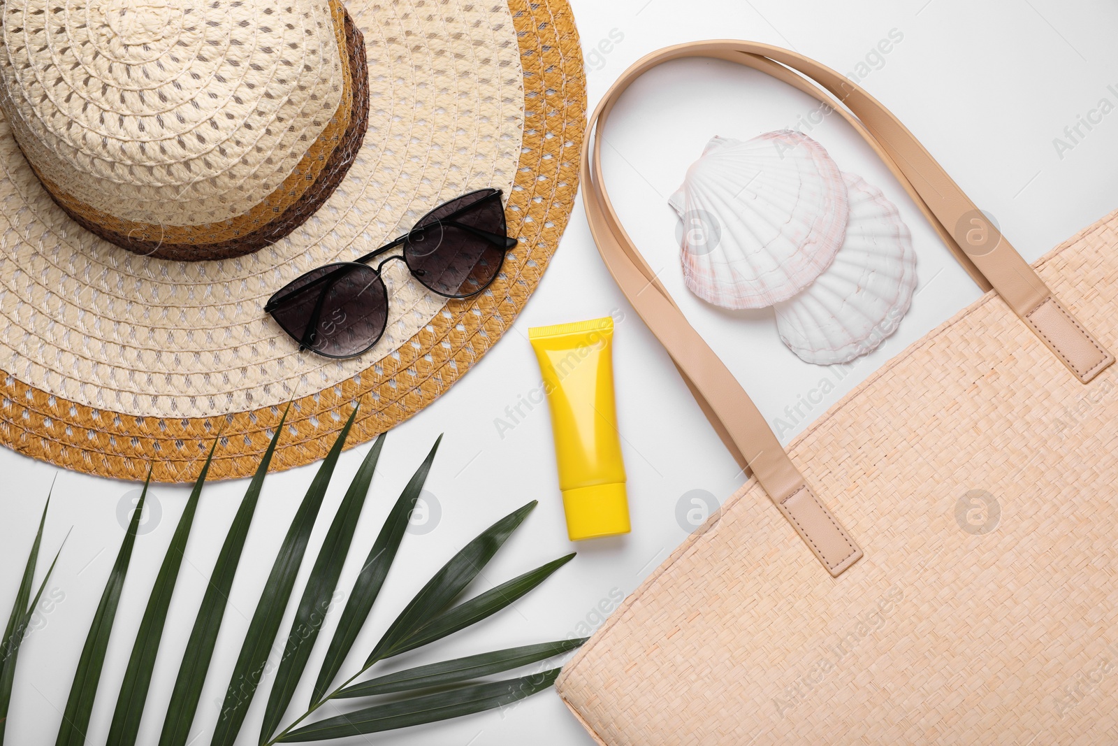 Flat lay composition with sunscreen and beach accessories on white background Photo of Flat lay composition with sunscreen and beach accessories on white background