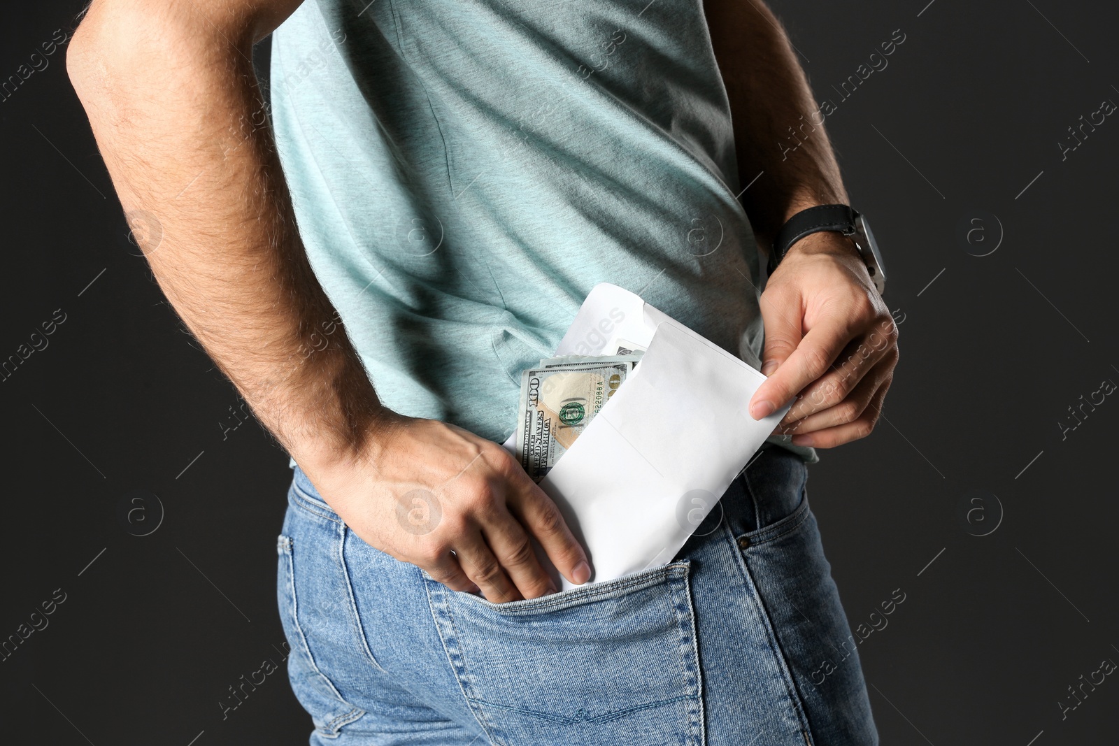 Photo of Man putting bribe money into pocket on black background, closeup