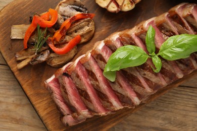 Delicious grilled beef steak with spices on wooden table, top view