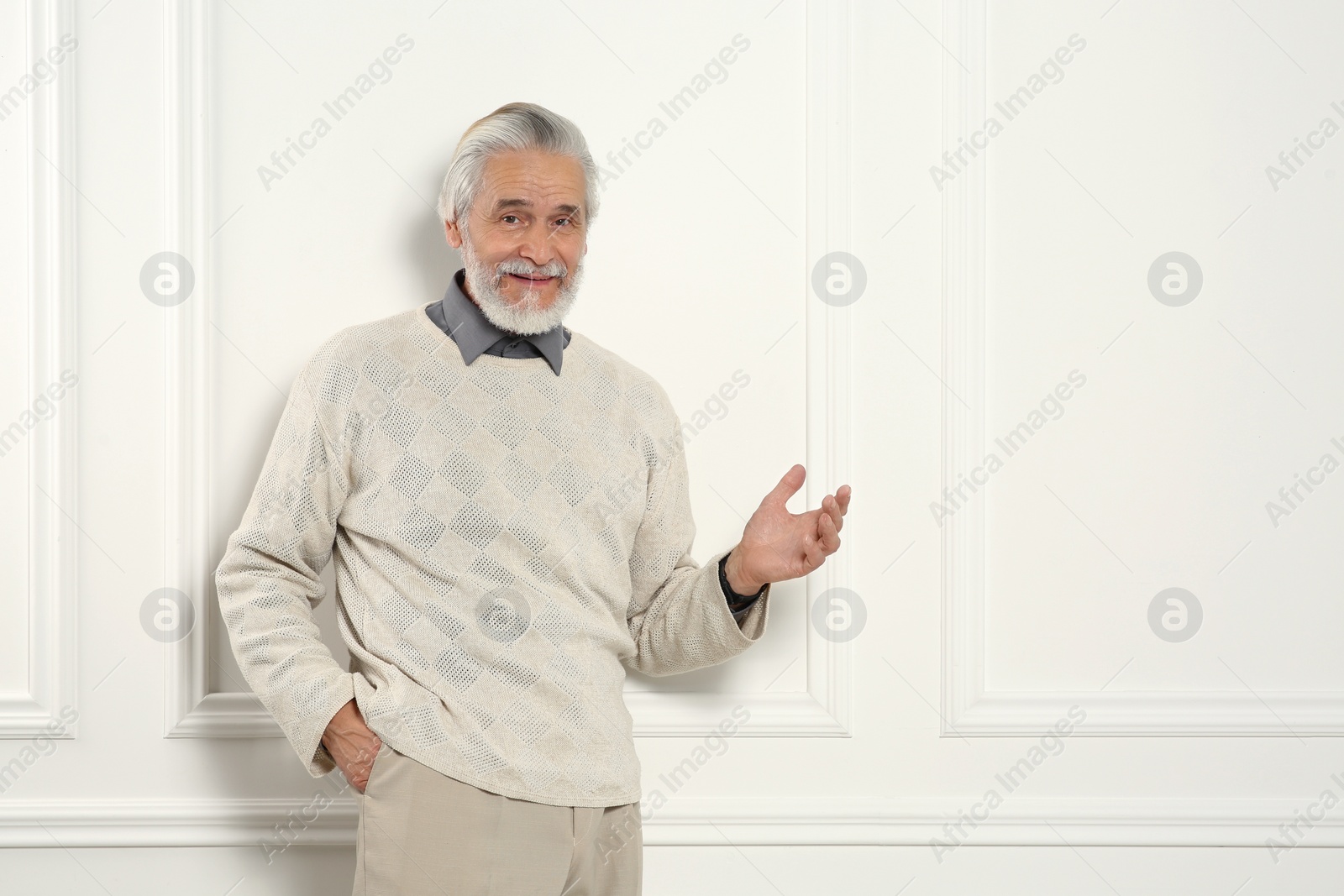 Photo of Portrait of handsome senior man near white wall. Space for text