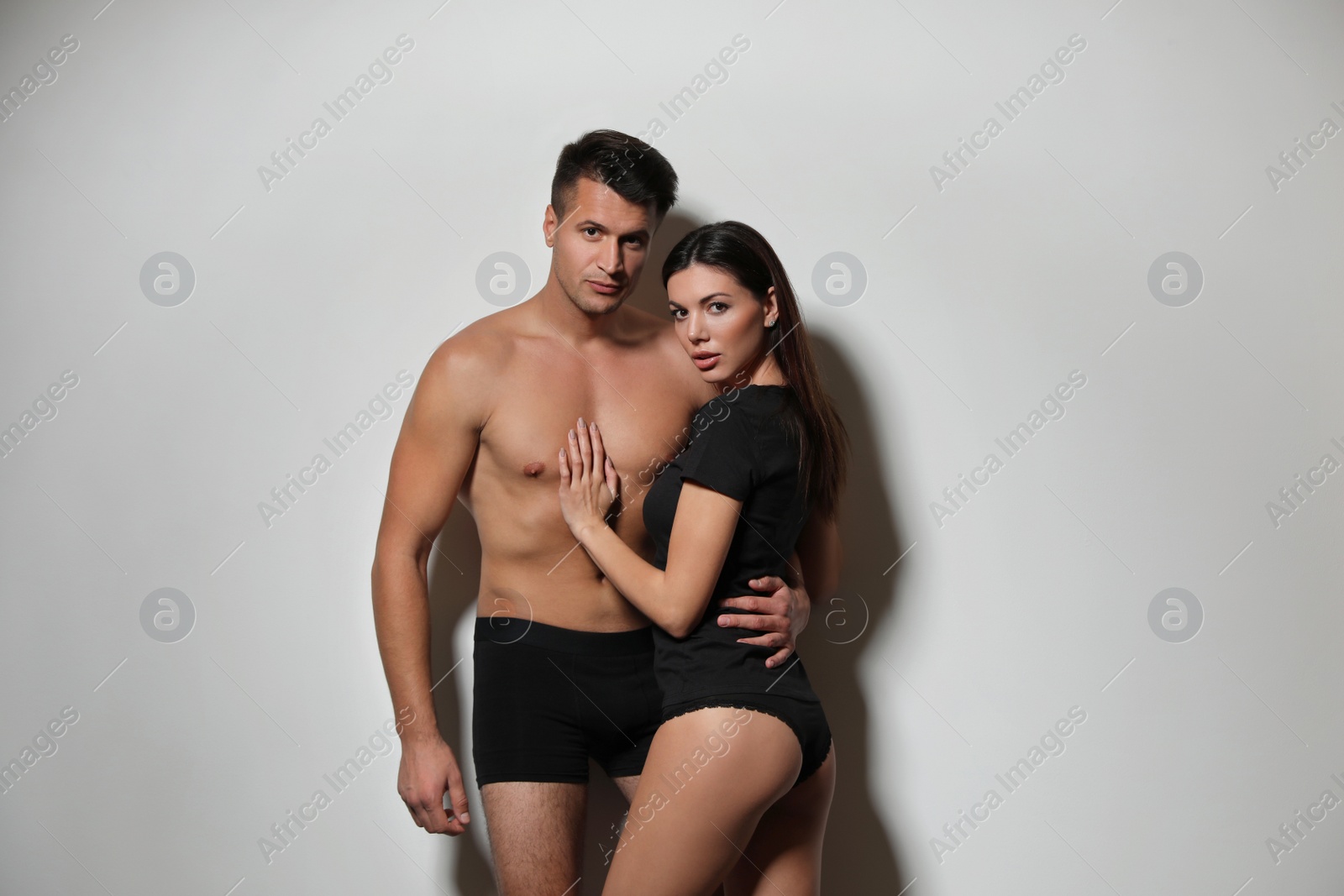 Photo of Young couple wearing underwear on light grey background