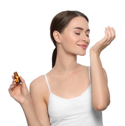 Young woman with bottle of essential oil on white background