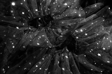 Beautiful black tulle fabric with shiny stars as background, closeup