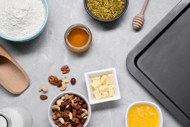 Different ingredients for making delicious baklava on grey textured table, flat lay