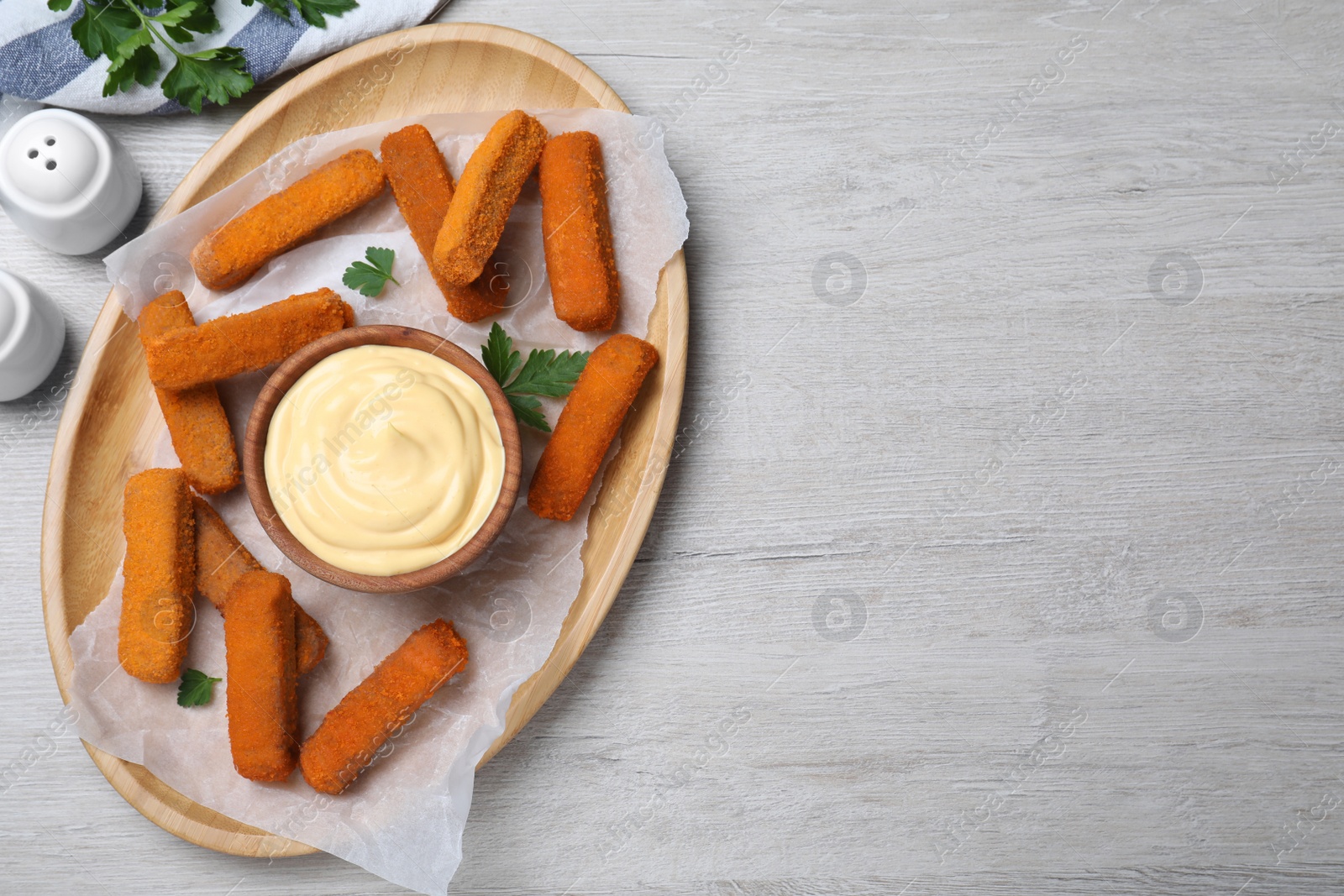 Photo of Delicious chicken nuggets and cheese sauce with parsley on white wooden table, flat lay. Space for text