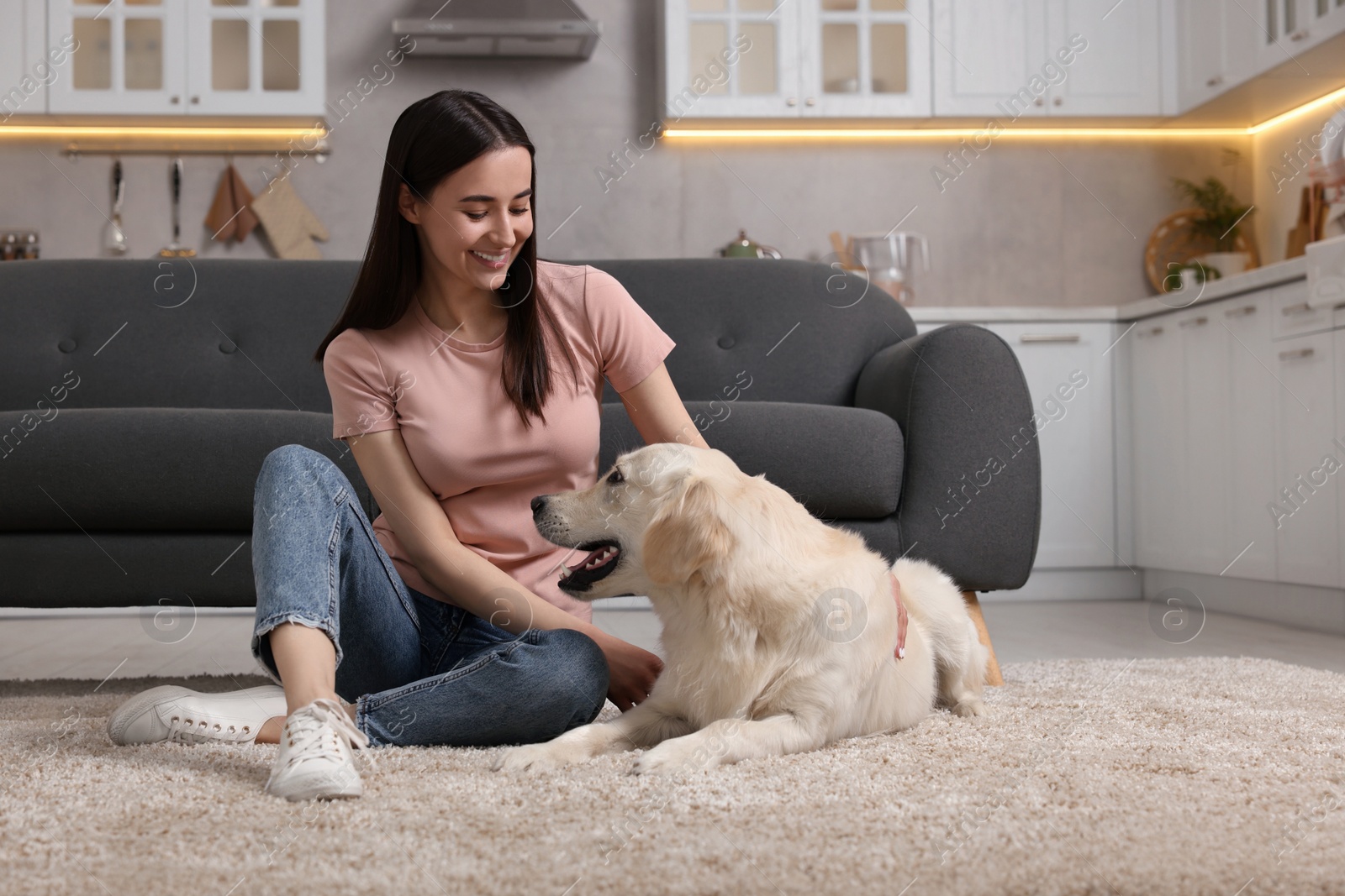 Photo of Happy woman with cute Labrador Retriever dog on floor at home. Adorable pet