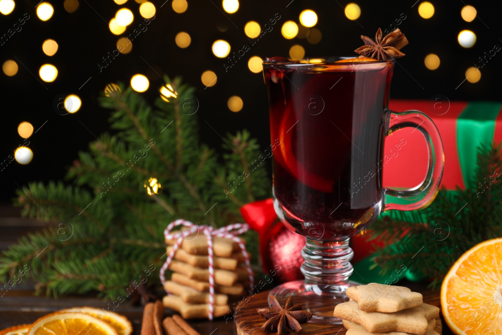 Photo of Christmas composition with aromatic mulled wine against blurred festive lights, closeup