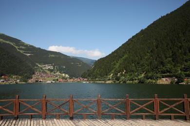 Photo of Buildings under mountains near lake on sunny day
