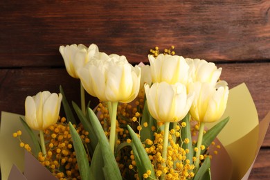 Bouquet with beautiful tulips and mimosa flowers on wooden table, top view