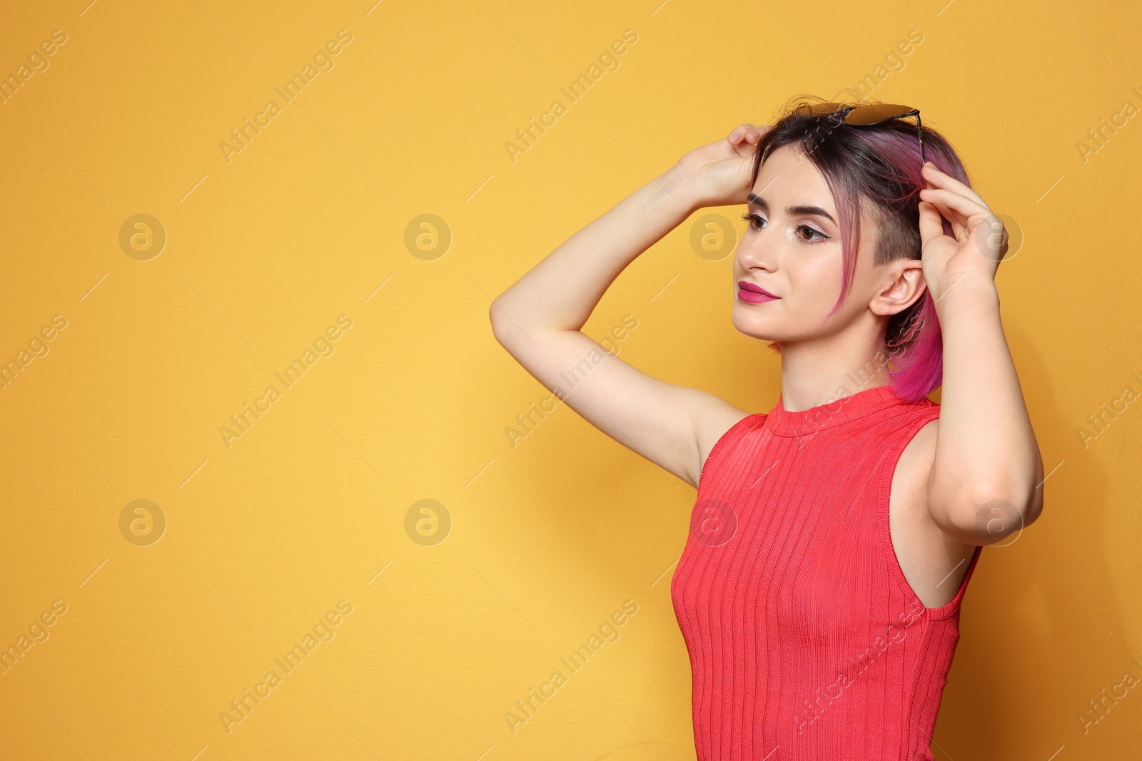 Photo of Young woman with trendy hairstyle against color background