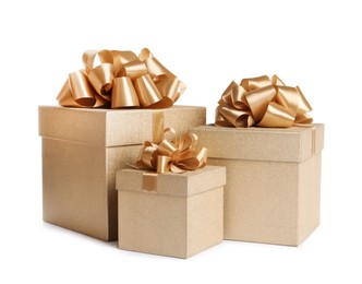 Photo of Golden gift boxes with satin bows on white background