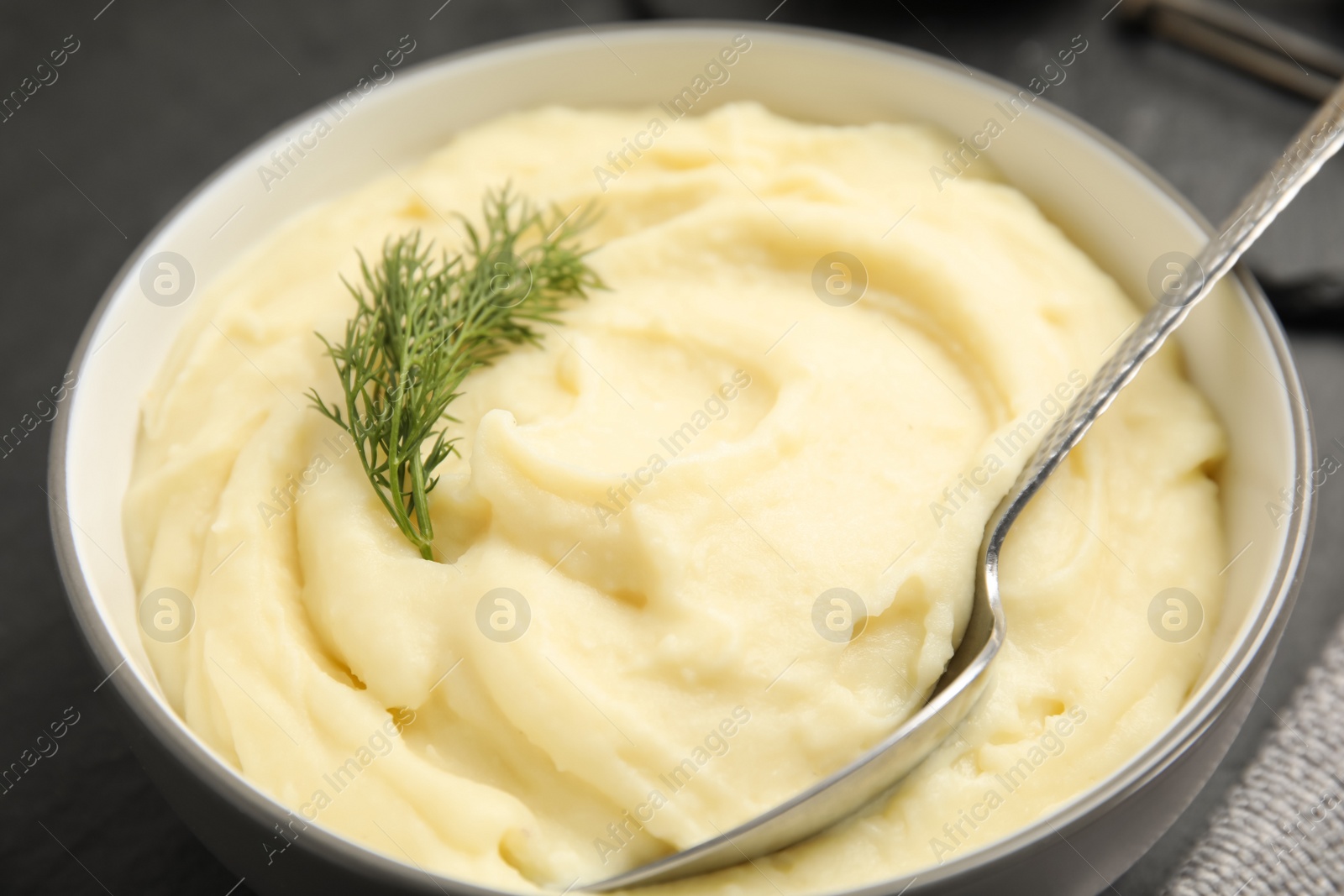 Photo of Freshly cooked homemade mashed potatoes on dark grey table, closeup