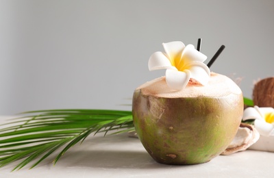 Fresh green coconut on table against gray background