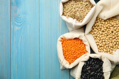 Photo of Different grains, seeds and space for text on light blue wooden table, flat lay. Veggie diet