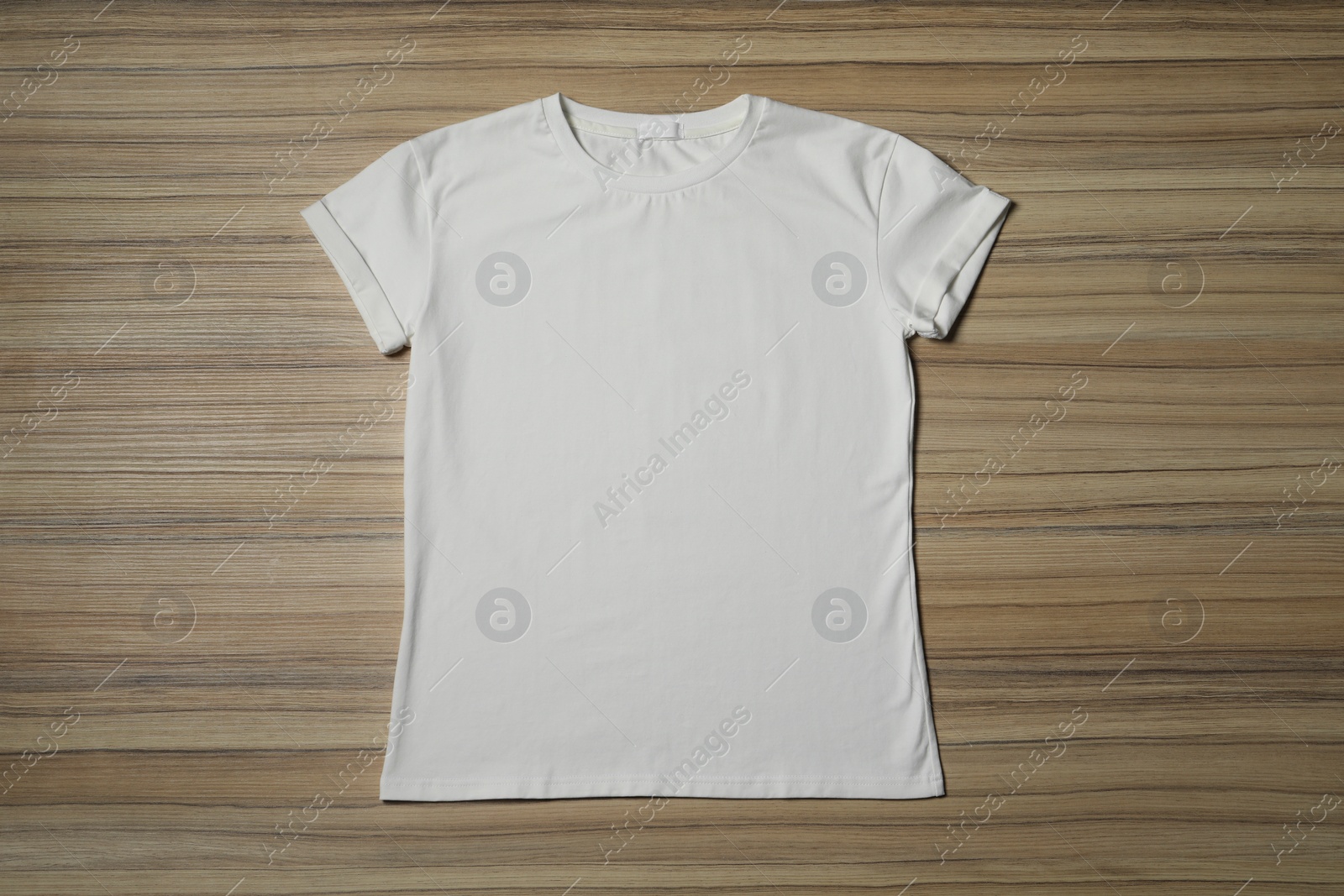 Photo of Stylish white T-shirt on wooden table, top view