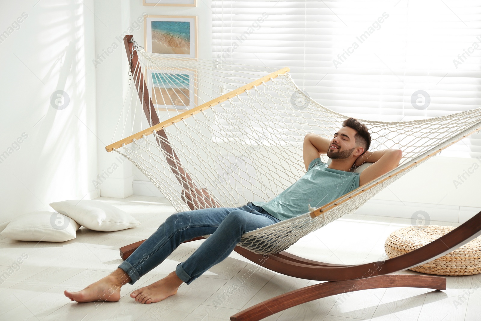 Photo of Young man relaxing in hammock at home