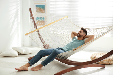 Young man relaxing in hammock at home