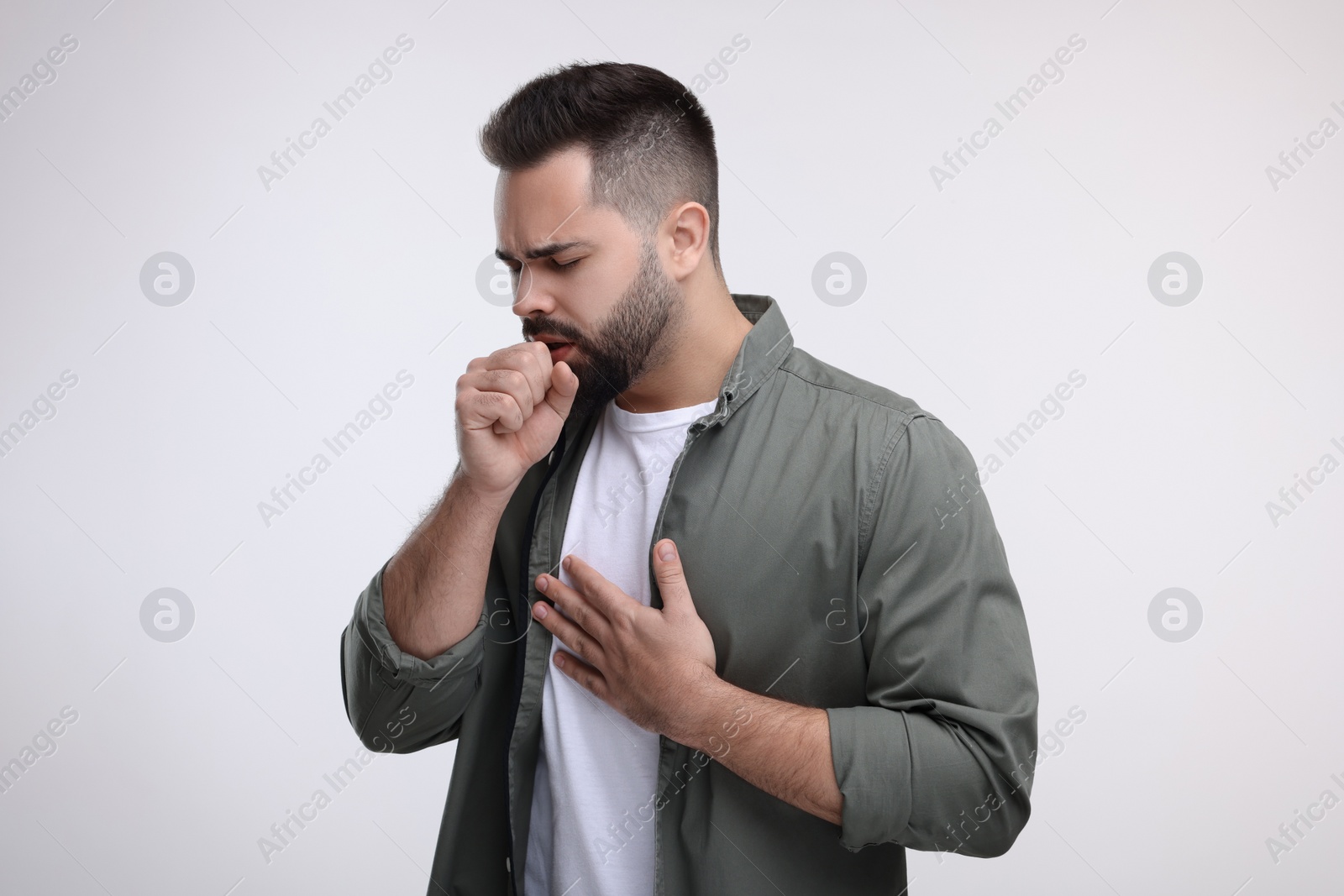 Photo of Sick man coughing on white background. Cold symptoms