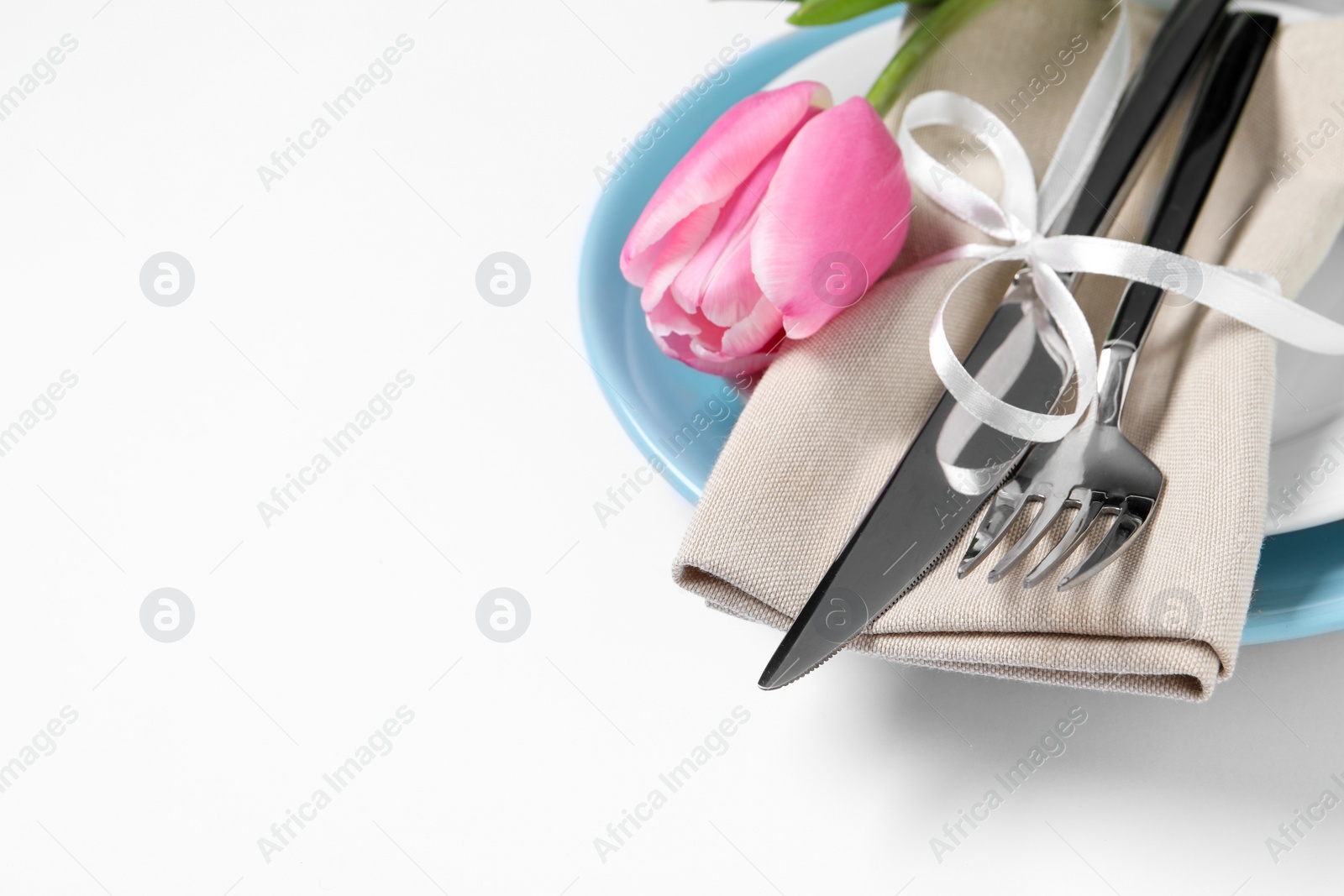 Photo of Stylish table setting with cutlery and tulip on white background, closeup. Space for text