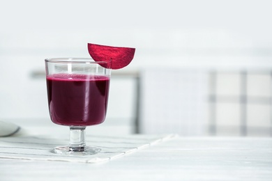 Glass of tasty beet smoothie on table with space for text