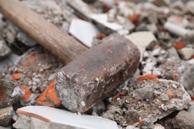 Photo of Sledgehammer on pile of broken bricks, closeup