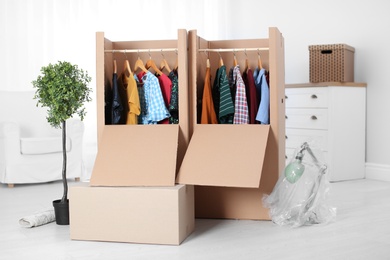 Photo of Wardrobe boxes with clothes in room interior